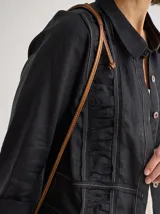 Camisa de lino blanca con diseño de frunces verticales en el frente, cuello camisero y cierre frontal con botones. Presenta mangas largas con puños y un corte recto y holgado.