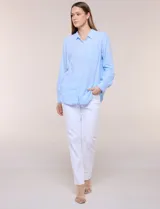 Camisa de lino marca Dash, color beige, con cuello con solapa, escote en V y cierre frontal con botones. Presenta mangas largas regulables con presilla y botón, y un bolsillo aplicado en el pecho.