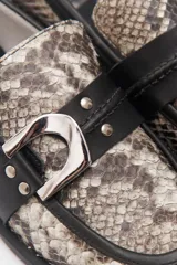 Mocasines de cuero con estampado animal print, detalle de hebilla plateada y suela plana.