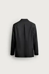 Blazer regular fit de Zara, confeccionado en lana de origen italiano, de color azul marino. Cuenta con cuello de solapas de muesca, cierre frontal de dos botones, bolsillos con solapa en la cadera y un bolsillo de vivo en el pecho.