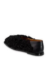 Zapato bajo negro de cuero con detalle de piel sintética rizada en la parte delantera.