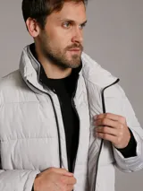 Campera puffer Calvin Klein acolchada, de color gris claro, con cuello alto, cierre frontal con cremallera negra y bolsillos laterales con cierre.