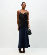 Pollera midi de satén color negro, con corte evasé y cintura elástica. Presenta una caída fluida y suave con acabado brillante.