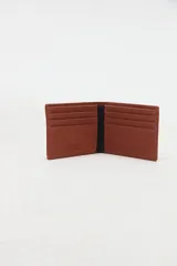 Billetera de canvas de algodón color marrón, con compartimentos internos y detalle de etiqueta bordada con el logo "Uniform Social Club" en el frente.