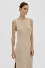 Vestido largo tejido en jersey color beige, con escote redondo y corte con abertura en los laterales.