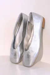 Ballerinas doradas con punta redondeada y suela plana color madera.