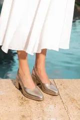Zapato destalonado de cuero vacuno color blanco, con punta fina, taco ancho y tira elástica ajustable en el talón.
