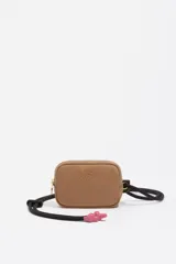 Billetera compacta de Bimba y Lola en color beige, con cierre superior y correa de cuerda negra ajustable con detalles en color fucsia.