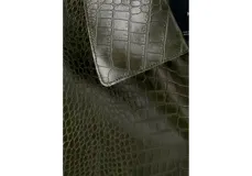 Chaqueta verde oscuro de poliuretano con acabado efecto cocodrilo, corte recto, bolsillos con solapa en el frente y cierre de botones.