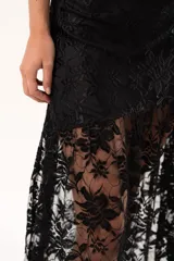 Pollera larga de encaje negro con silueta fluida y diseño asimétrico. Presenta un forro interno hasta la altura del frunce, dejando la parte inferior con transparencias que aportan movimiento.