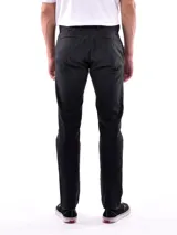 Pantalón de vestir negro, de corte recto, con bolsillos laterales y traseros. Se ajusta a la cintura con cinturón de cuero marrón.