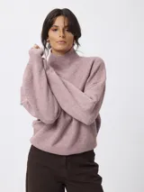 Sweater de punto en color gris, con cuello alto tipo tortuga y diseño de calce holgado con mangas largas.