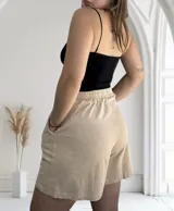 Short color beige con efecto lavado, cintura elastizada y bolsillos laterales.