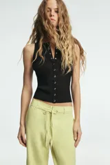 Pantalón de tiro medio confeccionado en mezcla de lino, con cintura ajustable mediante lazada, trabillas, bolsillos laterales y cierre frontal con cremallera y botón.