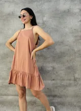 Vestido corto color durazno, con breteles finos y falda con volados.