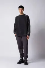 Buzo de cuello redondo con efecto lavado, corte oversize y costuras expuestas en color contrastante.