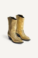 Botín de piel estilo cowboy con acabado metalizado dorado, cordones en el empeine, tacón medio ancho asimétrico y puntera perfilada.