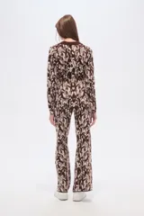 Pantalón de tejido de punto con tiro alto y calce ancho, presentando un estampado pixelado o camuflado en tonos marrón, beige y blanco.