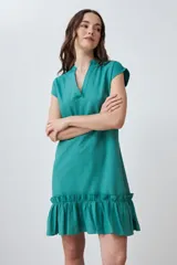 Vestido corto de color rojo con cuello en V, mangas cortas integradas y un detalle de volado en el ruedo. Presenta un diseño de silueta holgada y minimalista.