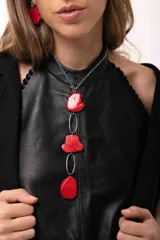 Collar largo con diseño de eslabones metálicos intercalados con piedras irregulares de color rojo intenso. Cuenta con una cadena de acero quirúrgico y cierre de gancho ajustable.