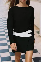 Falda pantalón negra de tiro alto con diseño cruzado en el delantero y un detalle de cinturón o banda ancha blanca contrastante en la cintura.