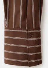 Camisa de algodón con diseño de rayas verticales en tonos marrón y beige, de manga larga, cuello camisero y cierre frontal de botones.
