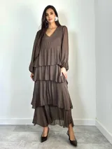 Vestido largo de seda italiana color chocolate, con escote en V, mangas largas abullonadas y diseño de falda con volados escalonados.
