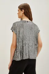 Remera azul marino con lentejuelas verticales, cuello redondo y mangas cortas.