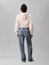 Buzo cropped con capucha y cierre frontal de Calvin Klein, confeccionado en punto milano. Presenta mangas largas con puños acanalados, dobladillo inferior también acanalado y cordones ajustables en la capucha.