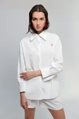 Short de tiro medio confeccionado en algodón tussor, de color blanco con costuras a la vista en color rojo. Presenta tablones delanteros que aportan volumen y un pequeño bordado con la letra V en el ruedo.