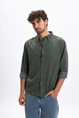 Camisa de manga larga confeccionada en micropana color verde militar, con cuello abotonado, bolsillo frontal y cierre de botones.