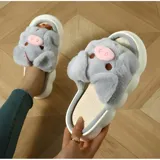 Pantuflas de peluche gris con diseño de chanchito, con suela de goma blanca y modelo abierto sin talón.