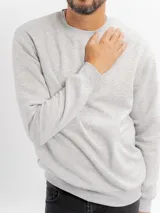 Buzo de felpa color beige, de cuello redondo y mangas largas con puños acanalados.