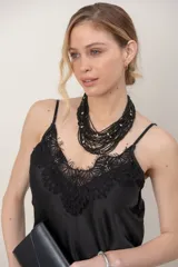 Musculosa de satén color beige con aplicación de encaje negro en el escote y breteles finos ajustables.