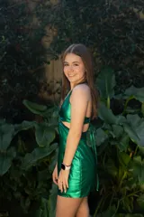 Vestido corto de fiesta color lila metalizado, con escote en V, breteles finos, cut-outs en la cintura y falda ajustada con cordones laterales.