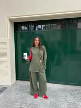 Conjunto gris melange confeccionado en lanilla, compuesto por una remera de manga larga con diseño cruzado en el frente y un pantalón largo de corte ancho con bolsillos.
