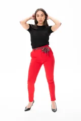 Pantalón rojo de corte Aline con cintura plisada y lazo decorativo.