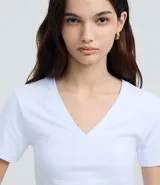 Blusa de corte regular confeccionada en algodón con elastano, con escote en V, mangas cortas y diseño liso.