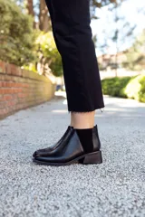 Botín negro de cuero con elástico lateral de gamuza y taco cuadrado bajo.