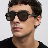 Lentes de sol con montura negra de diseño aviador contemporáneo, con doble puente estructural y lentes polarizadas en tono marrón.