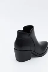 Bota corta de cuero sintético color marrón oscuro, con diseño minimalista, puntera afinada y taco ancho de altura media.