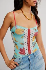 Body ajustado de nylon con estampado floral y paneles combinados de encaje y tul con lunares, tiras finas rojas y cierre frontal con cremallera.