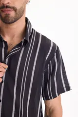 Camisa de manga corta de tejido jacquard, con diseño a rayas verticales en color negro y gris.