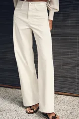 Jeans Z1975 wide leg de tiro alto color crudo, con bolsillos delanteros, bolsillos de parche en la espalda, costuras laterales destacadas y cierre frontal con cremallera y botón.