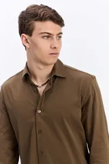 Camisa de manga larga color verde militar, con cuello tradicional y cierre frontal de botones.