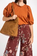 Remera de algodón negro con mangas cortas abullonadas, cuello redondo y costura central frontal.