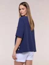 Blusa de algodón azul marino, con cuello redondo, mangas cortas amplias y detalle de botones en el lateral.