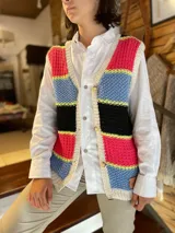 Chaleco tejido a mano de hilo de algodón, con diseño de franjas horizontales en colores fucsia, celeste, negro y detalles en amarillo flúor, escote en V y cierre frontal con botones.