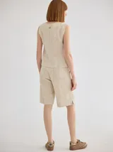 Short negro de lino, tiro medio y corte a la rodilla. Presenta botón de madera y costuras a contratono.