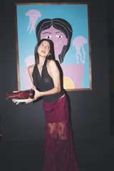 Falda midi asimétrica de encaje color bordó, con diseño translúcido y corte lánguido.